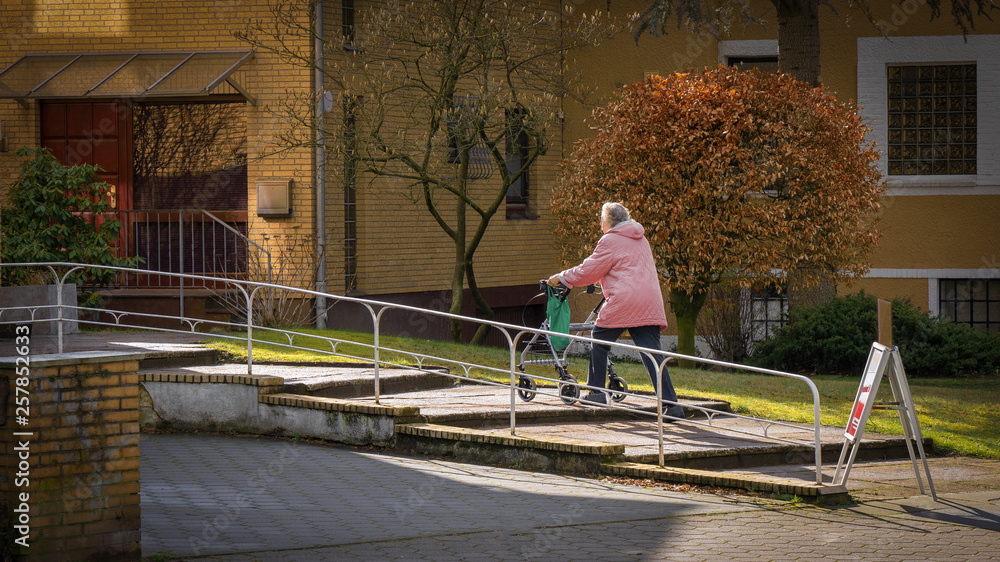 Alte Frau mit Rollator geht Stufen hoch Alte Frau mit Rollator geht Stufen hoch