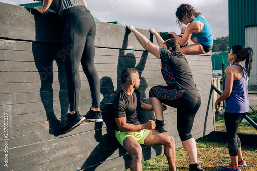 Foto Group of participants in an obstacle course climbing a wall