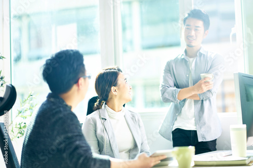 Wallpaper Mural three young asian business people chatting in office Torontodigital.ca