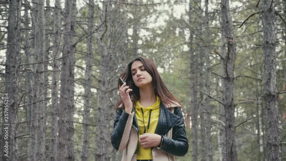 Pretty girl seeking a signal to call from her smartphone in a forest in slo-mo Pretty girl seeking a signal to call from her smartphone in a forest in slo-mo