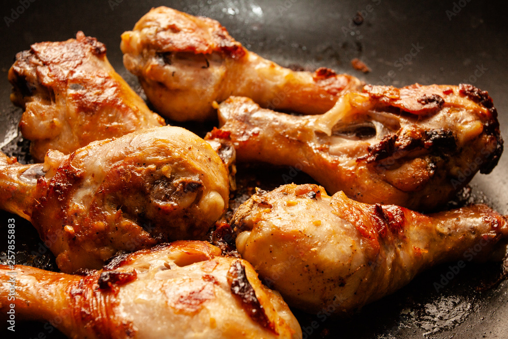 Roasted chicken legs on the black background. Top view. Roasted chicken legs on the black background. Top view.