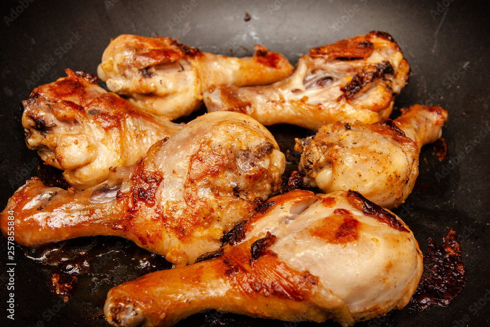 Roasted chicken legs on the black background. Top view. Roasted chicken legs on the black background. Top view.