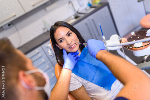 A young Dentist treating a female Patient in the dental studio