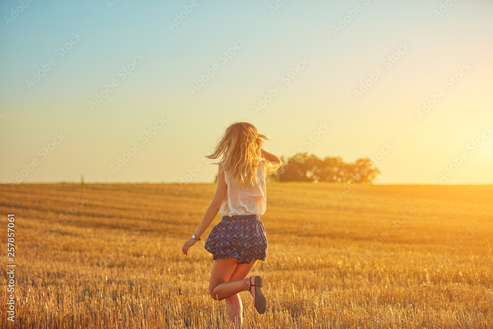 Cute young woman jumping in a wheat field. Cute young woman jumping in a wheat field.