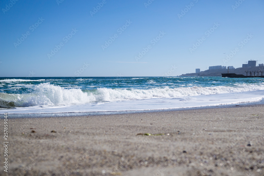Sea waves on the beach, bright blue water