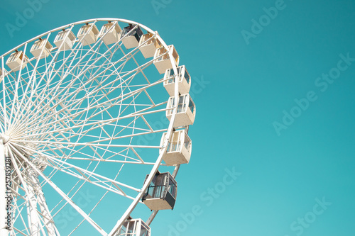 Big city ferris wheel on a background of clean blue sky photo