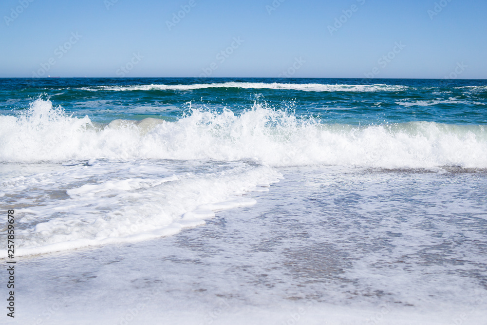 Fototapeta premium Sea waves on the beach, bright blue water