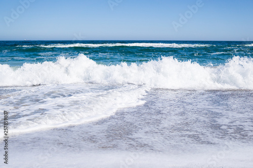 Sea waves on the beach  bright blue water
