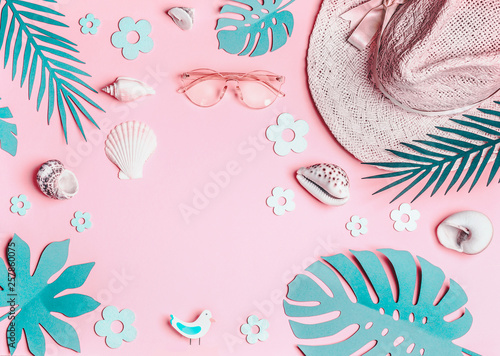 Summer background. Pastel pink woman accessories: straw hat with sunglasses , sea shells and turquoise blue tropical leaves on pink background, top view. Summer holiday concept. Tropical vacation .