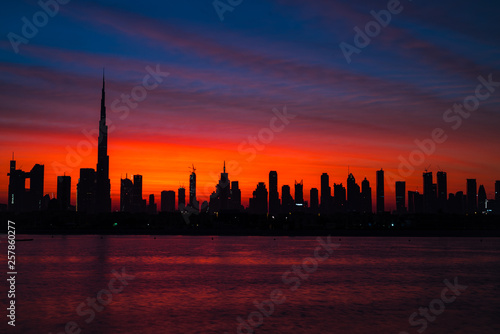 Mythical bloody red sky over Dubai. Dawn, morning, sunrise or dusk over Burj Khalifa. Beautiful colored cloudy sky over Dubai downtown . Glow over buildings or skyscrapers