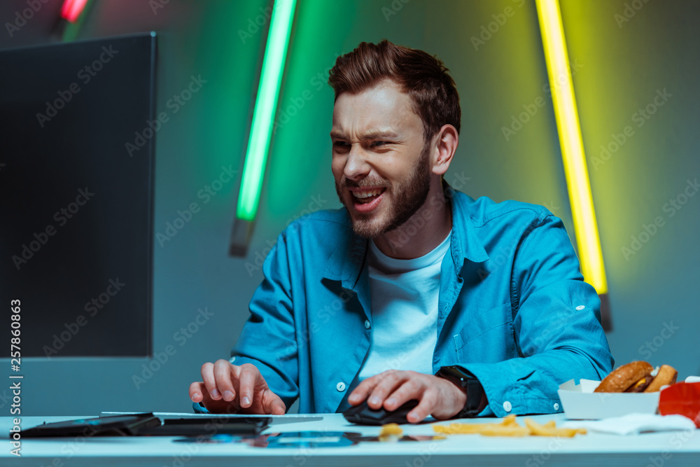 handsome and happy man playing video game with computer mouse and keyboard handsome and happy man playing video game with computer mouse and keyboard