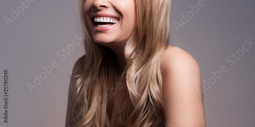Adult beautiful blond woman with white veneers on the teeth. photo