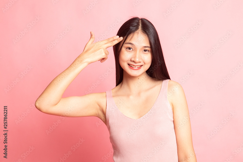 Beautiful young Asian woman holding fingers in gun gesture. Beautiful young Asian woman holding fingers in gun gesture.