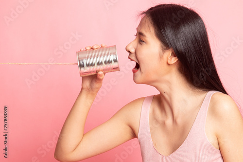 Young Asian woman shout with tin can phone.