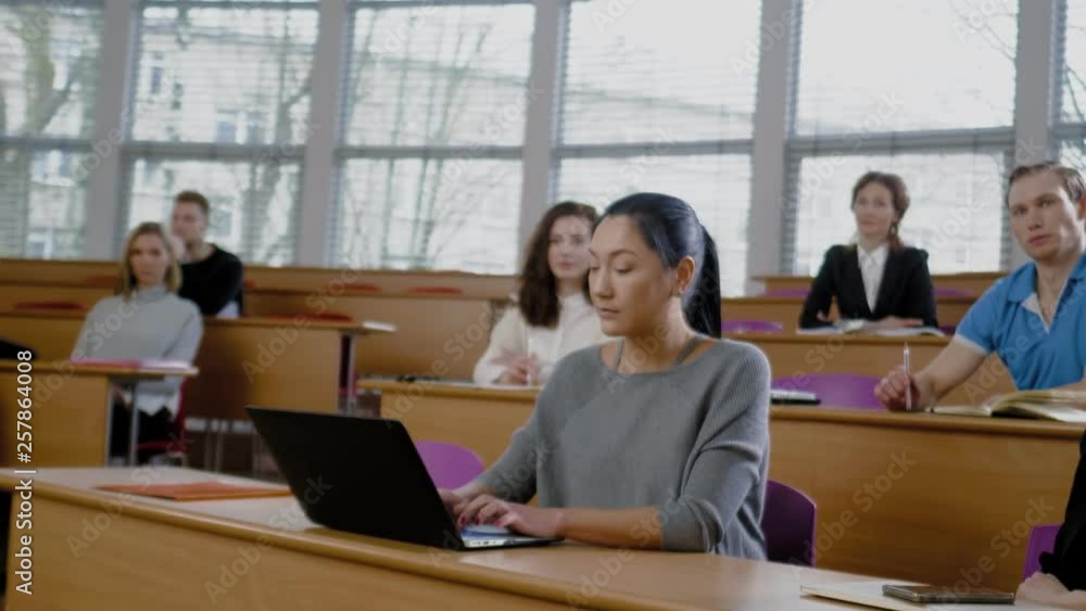 Lecturer and multinational group of students in an auditorium Lecturer and multinational group of students in an auditorium