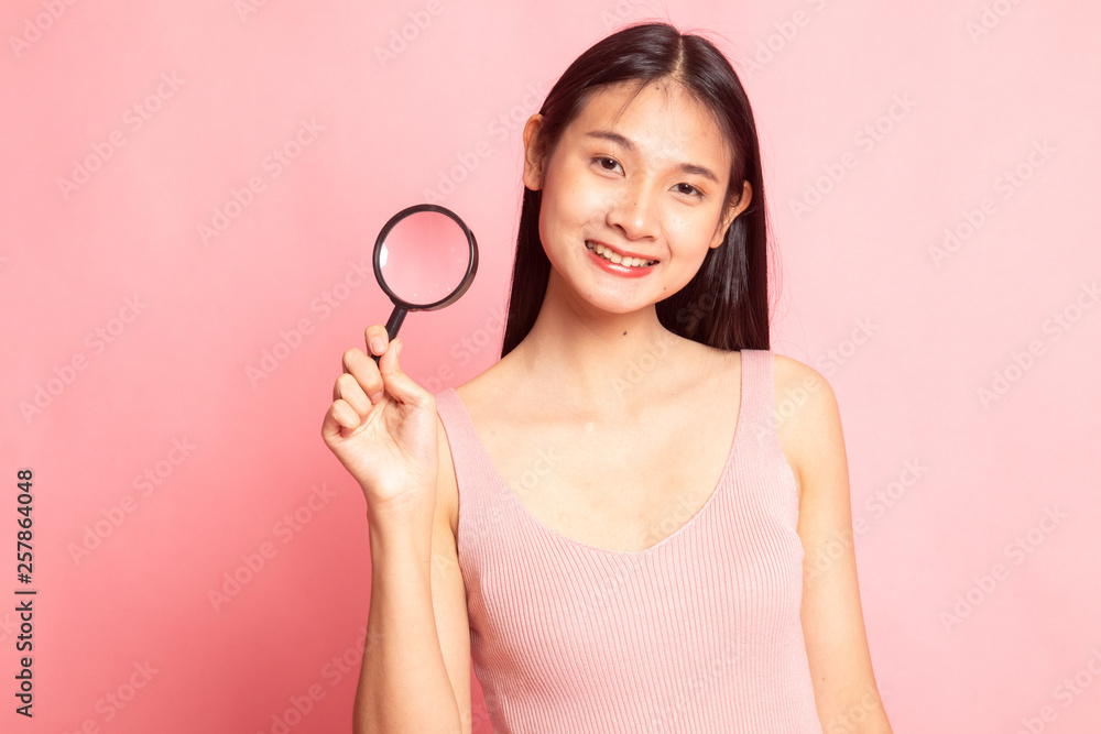 Young Asian woman with a magnifying glass. Young Asian woman with a magnifying glass.