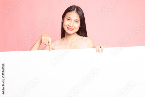 Young Asian woman point to a  blank sign.