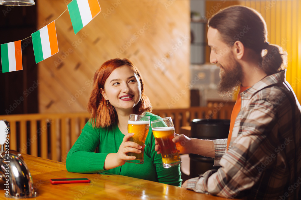 Woman wearing green shirt drinking beer with her new friend Woman wearing green shirt drinking beer with her new friend