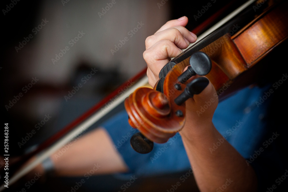 Young beautiful woman violin player looking at camera over instrument on her shoulder holding bow. Young beautiful woman violin player looking at camera over instrument on her shoulder holding bow.