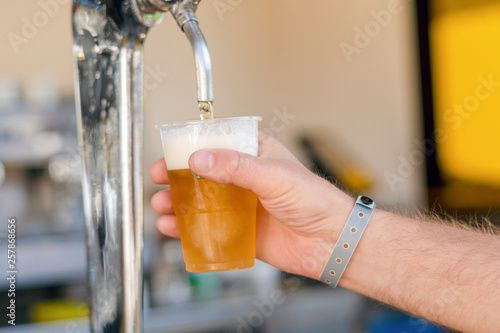 Man pouring fresh beer in self service bar - with all inclusive badge photo