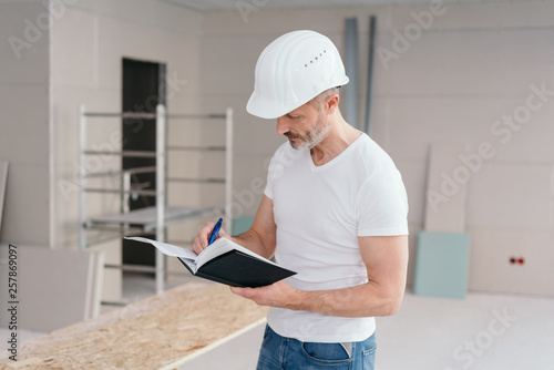 Builder making construction notes on a new build