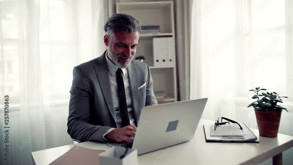 Businessman with computer sitting at the table in an office, working. Businessman with computer sitting at the table in an office, working.