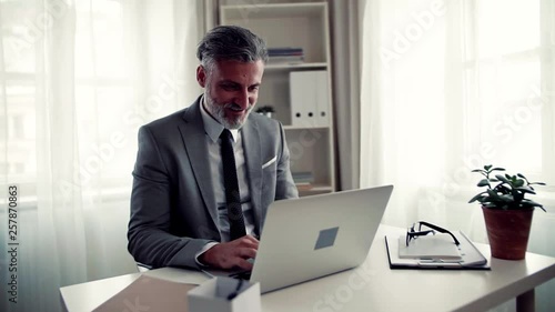 Wallpaper Mural Businessman with computer sitting at the table in an office, working. Torontodigital.ca