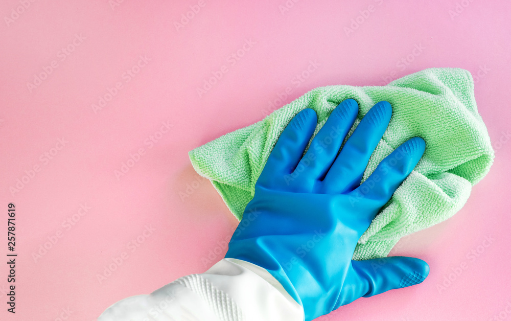 Employee hand in rubber protective glove with micro fiber cloth wiping wall from dust. Maid or housewife cares about house. Spring general or regular clean up. Employee hand in rubber protective glove with micro fiber cloth wiping wall from dust. Maid or housewife cares about house. Spring general or regular clean up.