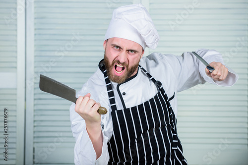 Chef with knifes. Professional in kitchen. culinary cuisine. angry bearded man with knife. love eating food. confident man in apron and hat. cook in restaurant, uniform. chef ready for cooking photo