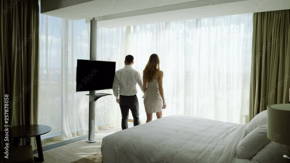 Young woman and man enjoying their suite, hugging and kissing at honeymoon vacation. 4K Young woman and man enjoying their suite, hugging and kissing at honeymoon vacation. 4K