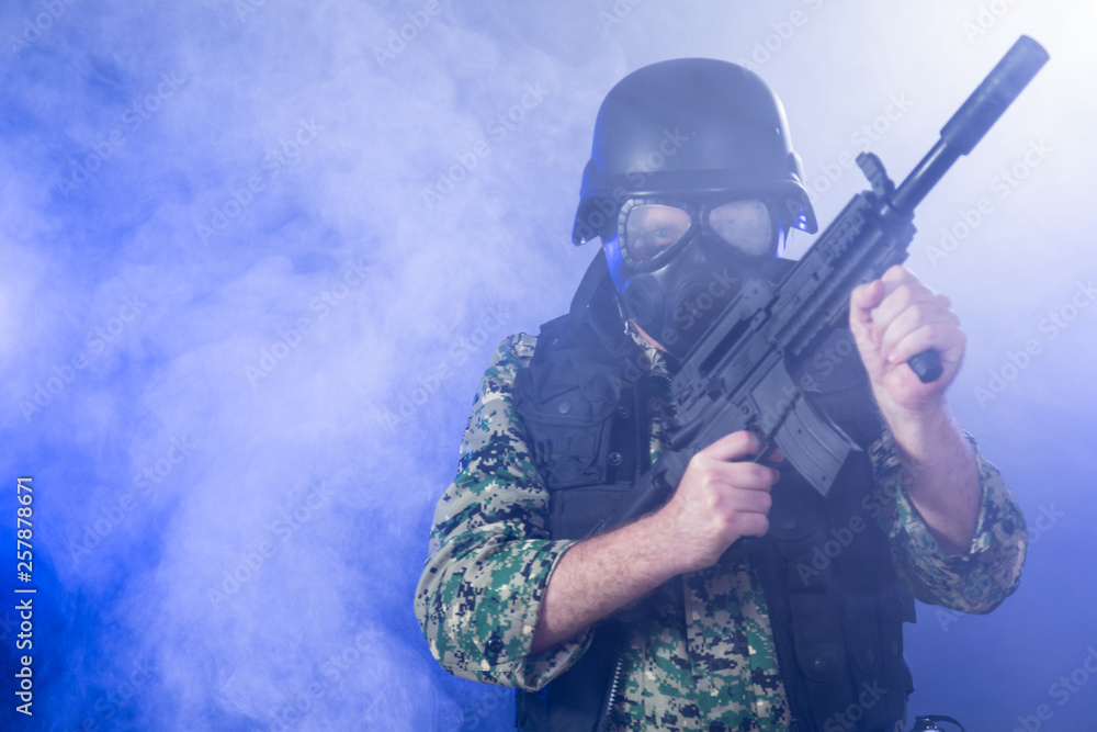 Soldier holding assault rifle in smoky haze Soldier holding assault rifle in smoky haze