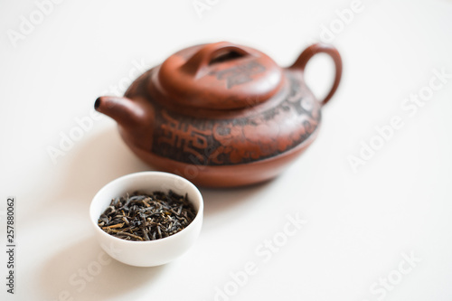 Clay teapot and the white drinking bowl of chinese tea on white background