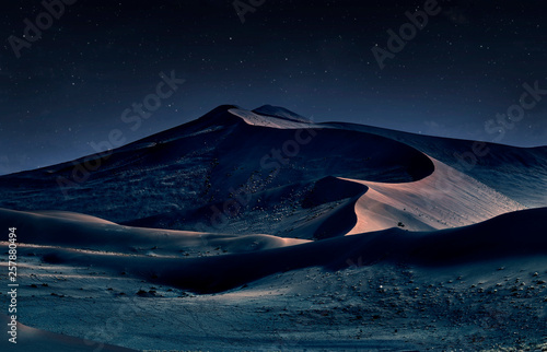 desert of namib at night with orange sand dunes and starry sky
