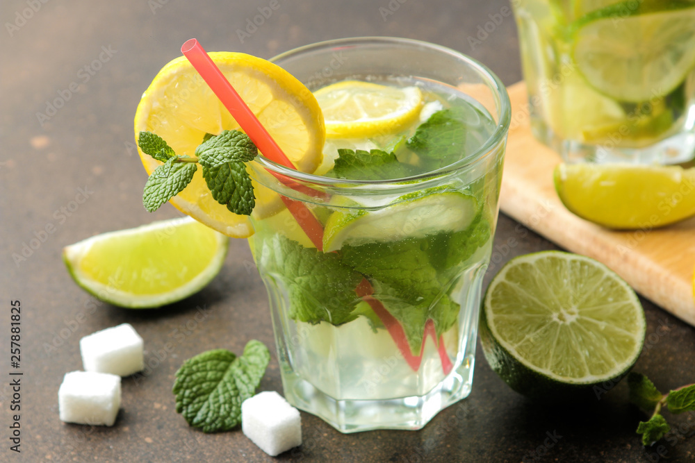 Mojito cocktail in a glass tumbler with lime, mint and lemon and on a dark concrete background. make a mojito. Mojito cocktail in a glass tumbler with lime, mint and lemon and on a dark concrete background. make a mojito.