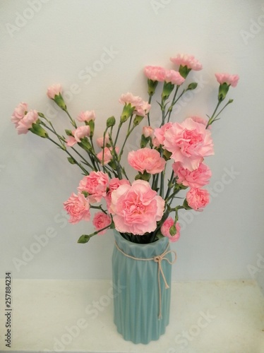 bouquet of pink carnations in a blue vase      
