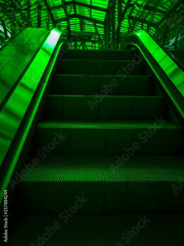 Metal ladder in green light  the subway. Pattern Escalator stairs Indoor. Stairs in the tunnel urban city streets. Close up of escalator step background