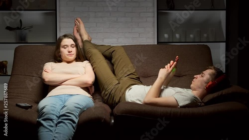 girl expresses dissatisfaction with her young man using smartphone for social media