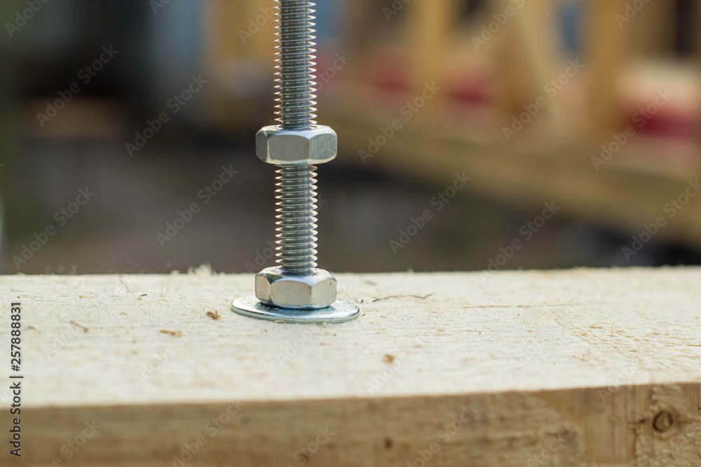 Bolt and nut twisted into a wooden board