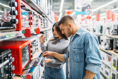 Foto Couple buys an electric oven in a supermarket