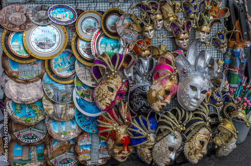 Closeup of a street stand selling souvenirs as carnival masks and plates in Pisa, Italy
