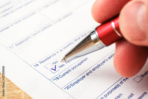 Schengen visa, questionnaire. Hand with pen completing a questionary. photo