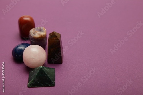 Magic stones and crystals of different shapes and colors lying in bulk on a bardic background. photo