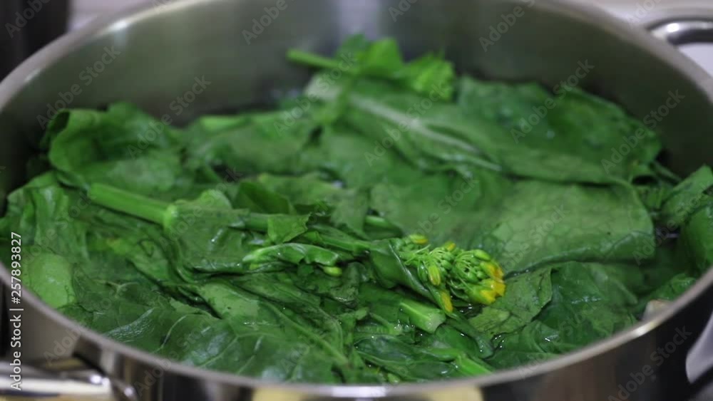 green fresh vegetables boiling in water in iron pot green fresh vegetables boiling in water in iron pot