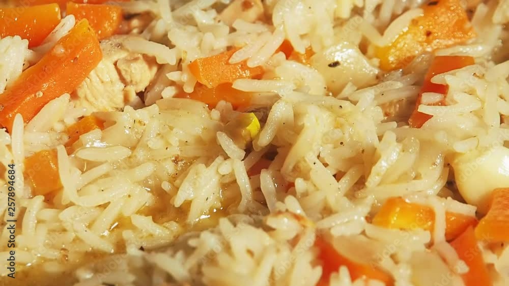 Boiling pilaf. Rice with carrots and meat slowly boils, extra close up view. Cooking of food, rice porridge with vegetables and meat. Boiling pilaf. Rice with carrots and meat slowly boils, extra close up view. Cooking of food, rice porridge with vegetables and meat.