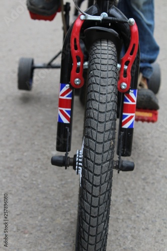 Fototapeta Naklejka Na Ścianę i Meble -  Children's bicycle with extra wheels, close-up.