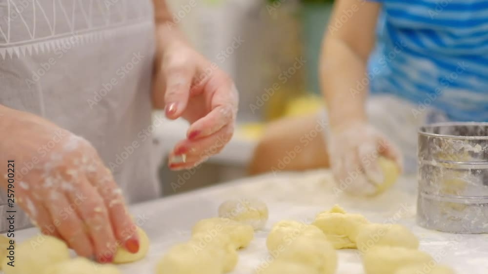 Little kid preparing dough on the table and sneezes. Little baby playing with flour. Baker prepares the dough Little kid preparing dough on the table and sneezes. Little baby playing with flour. Baker prepares the dough
