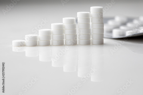 Growth graph made of stacked white pills - growing market and increasing demand for white pill and it s substitutes