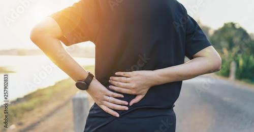 Back pain, sprain accident in sport exercise running jogging.sprain or cramp Overtrained injured person when training exercising or running outdoors.