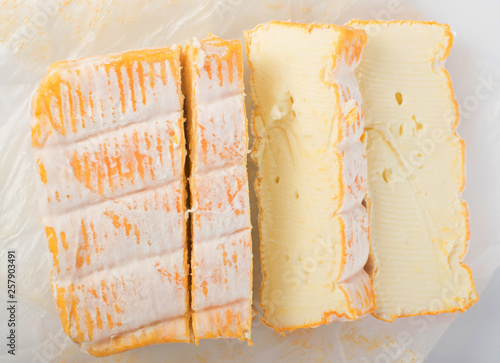 Cheeseboard with Sliced Yellow Limburger Cheese Top View photo