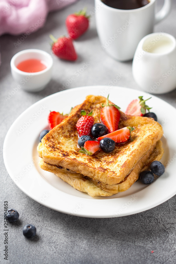 French toast with berries (blueberries, strawberries) and sauce, traditional sweet dessert of bread with egg and milk. Morning baking food French toast with berries (blueberries, strawberries) and sauce, traditional sweet dessert of bread with egg and milk. Morning baking food